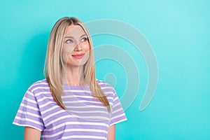 Portrait of pleasant gorgeous woman with straight hairdo dressed striped t-shirt looking empty space isolated on blue