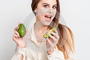 Portrait of pleasantly surprised woman with a two avocado