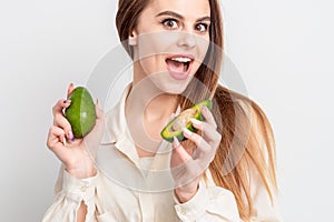 Portrait of pleasantly surprised woman with a two avocado photo