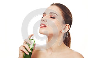 Portrait of pleased adorable woman with wonderful make up, uses her favourite parfume, looks beautifully, closes eyes with pleasur