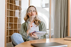 Portrait of pleased blond woman writing down notes