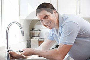 Portrait Of Plumber Mending Kitchen Tap