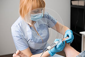 Portrait of podiatrist employs a milling machine for callus removal.