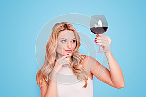 Portrait of ponder minded, expert, elegant pretty girlfriend looking at raised glass with alcohol beveragein hand with