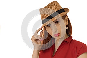 Portrait of the posing girl in a hat and a dress.