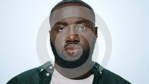 Portrait of positive african man making funny faces in grey background.