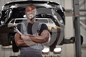 Portrait of positive afro american auto mechanic in uniform