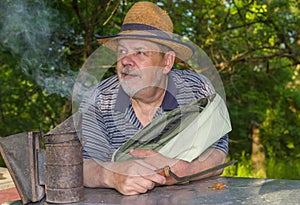 Portrait of positive bearded elderly man bee-keeper