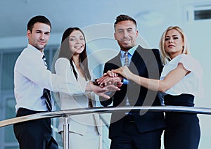 Portrait of positive business group standing on stairs of modern building.