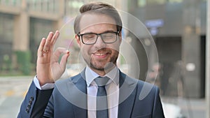 Portrait of Positive Businessman showing OK Sign