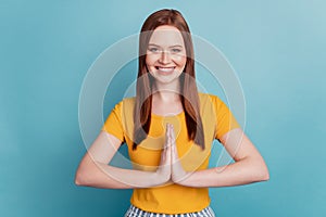 Portrait of positive charming lady hold palms together plead on blue background