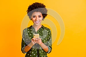 Portrait of positive cheerful afro american girl social network addicted user hold smartphone read social media news