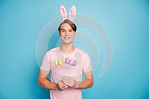 Portrait of positive cheerful guy celebrate easter holidays theme party hold green yellow pink purple chocolate eggs
