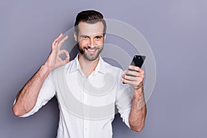 Portrait of positive confident man marketer agent man use smart phone search excellent social network ads approve