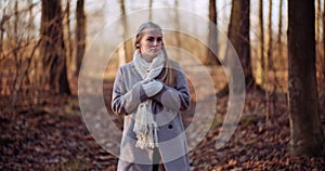 Portrait of positive female walking in woods in autumn