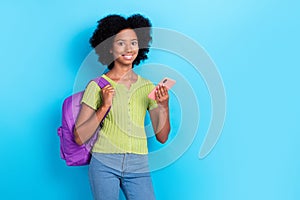 Portrait of positive girl curly hair green t-shirt hold smartphone facebook twitter instagram whatsapp isolated on blue