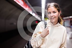 Portrait of a positive girl in the subway waiting for a train