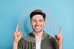 Portrait of positive guy promoter point index finger empty space indicate promo ads isolated over blue color background