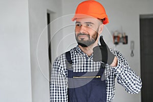 Portrait of positive, handsome young male builder in hard hat