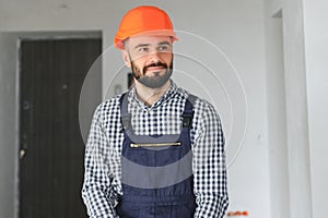 Portrait of positive, handsome young male builder in hard hat