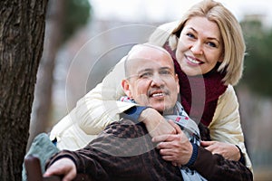 Portrait of positive happy smiling mature couple in city
