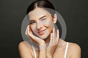 Portrait of positive lovely pretty brunette woman touching her hands her face enjoying her soft pure perfect skin over black color