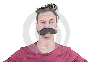 Portrait of a positive man with cardboard mustache and arched eyebrow, isolated on white background