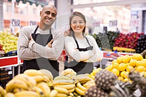 Portrait of positive man and woman salesmen at supermarket