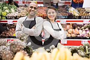 Portrait of positive man and woman salesmen at supermarket