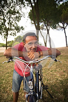 Portrait of positive mature man riding bicycle