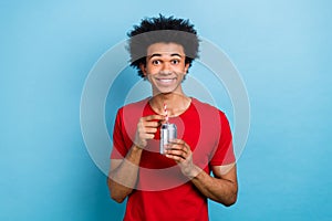 Portrait of positive nice person beaming smile hands hold soda drink can straw isolated on blue color background