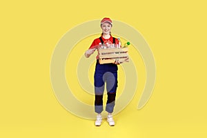 Portrait of positive optimistic worker woman standing and pointing at plastic bottles in box.