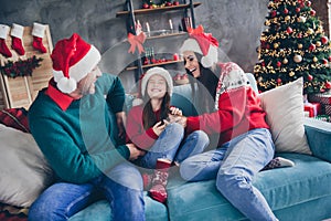 Portrait of positive parents sit couch tickle excited laughing small girl x-mas atmosphere house indoors