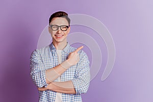 Portrait of positive promoter guy indicate finger empty space on violet background