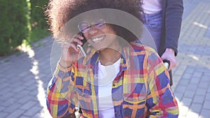 Portrait of a positive smiling young African American woman disabled in a wheelchair talking on the phone