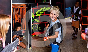 Portrait of positive tweenager boy with laser gun