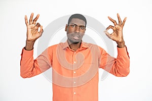 Portrait of positive young man making okay gesture