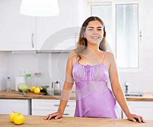 Portrait of positive young woman in kitchen at home