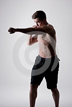 Portrait of powerful fighter man in fighting stance on white background