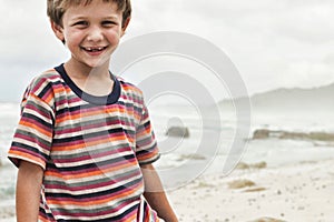 Portrait of a preadolescent boy smiling while standing at beach