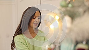 Portrait of a pregnant girl near a Christmas tree.