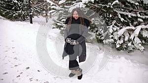 Portrait of pregnant girl in a park at a snowfall.