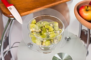 Portrait of pregnant mother cuts kiwi fruit