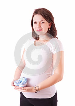Portrait of pregnant woman with baby shoes