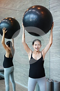 Portrait of pregnant woman exercising with fitball at sports hall