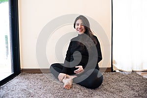 Portrait of pregnant woman : Happy Asian pregnant woman touching her belly with care at home