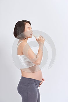 Portrait of pregnant woman with milk in glass at home