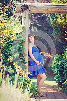 Portrait of pregnant woman in park outside