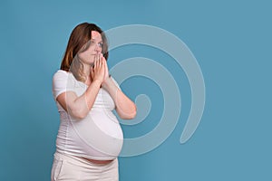 Portrait of a pregnant woman with a plea on a blue background photo