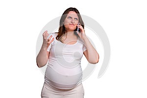 Portrait of a pregnant woman talking angrily on the phone on a white b